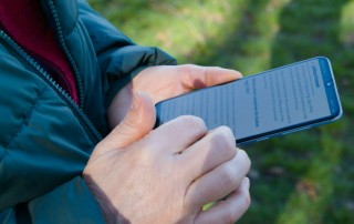 Person checking a website on a smartphone outdoors
