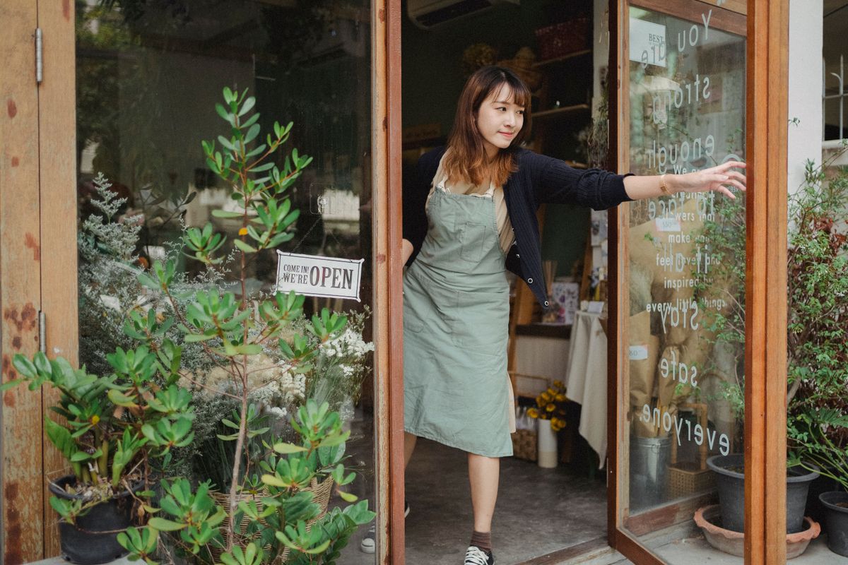 Local flower shop owner opening the storefront door