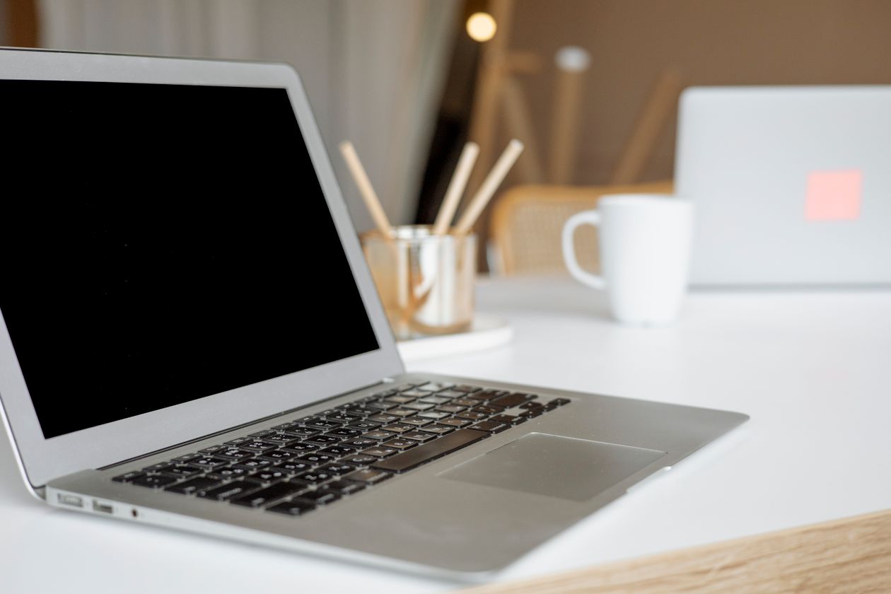Laptop on an organized desk for a business domain renewal checklist