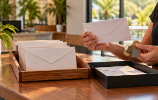 A business employee independently verifies an envelope and account keys at a sunlit office desk.